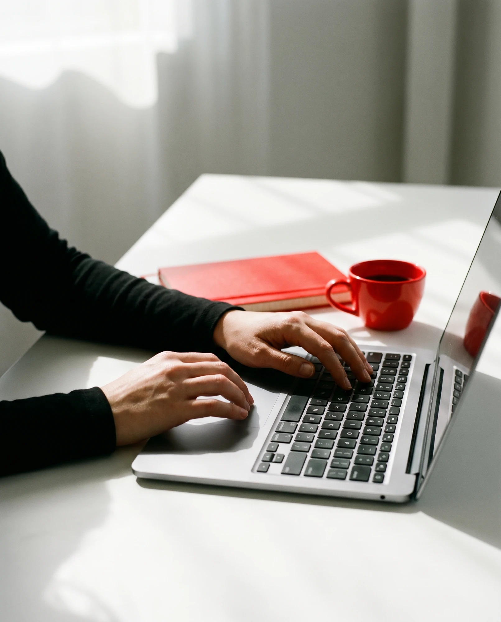 Hands at a laptop, planning and writing a campaign